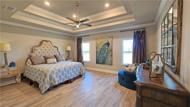 bedroom featuring a tray ceiling, light hardwood / wood-style flooring, ceiling fan, and ornamental molding