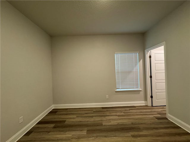 empty room featuring dark hardwood / wood-style flooring and a textured ceiling