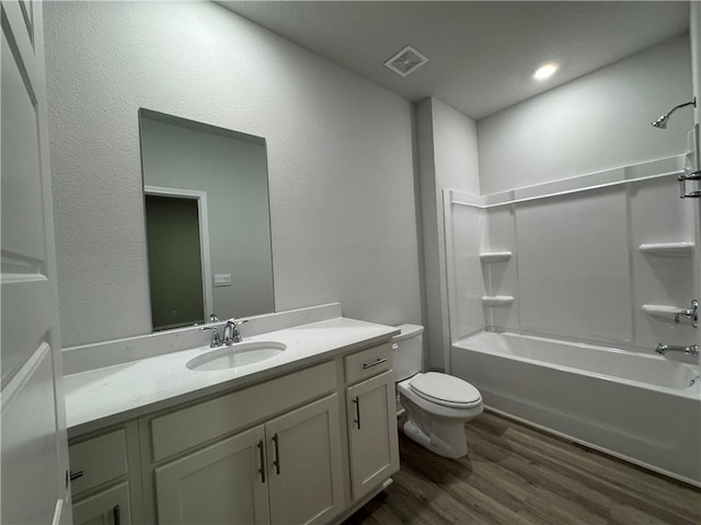 full bathroom with vanity, shower / bath combination, hardwood / wood-style flooring, and toilet