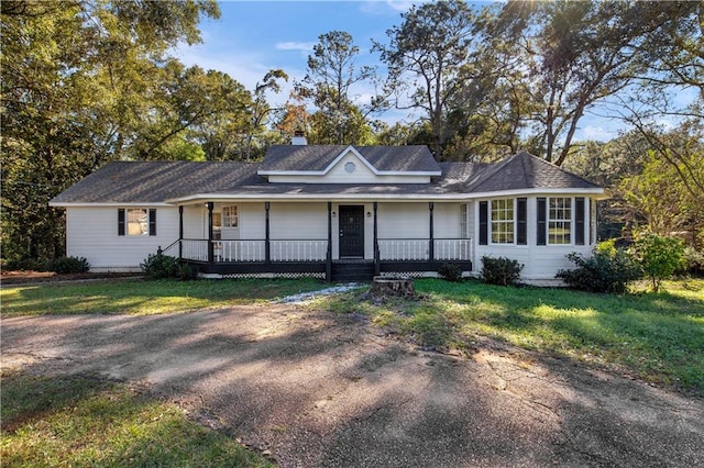 ranch-style house featuring covered porch and a front lawn