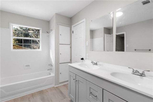 bathroom featuring hardwood / wood-style floors, vanity, and tub / shower combination