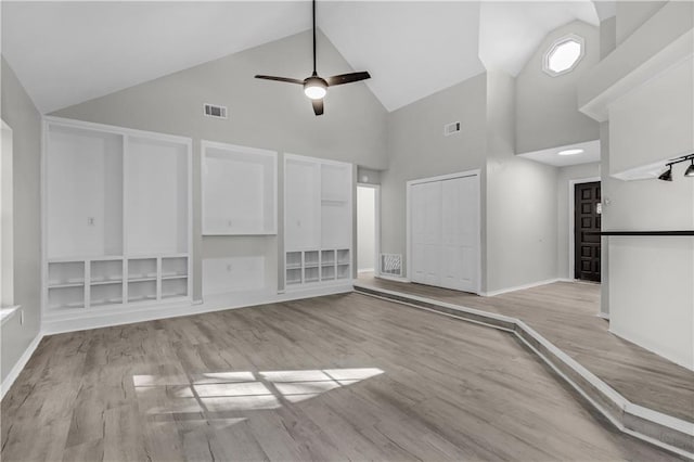 unfurnished living room featuring ceiling fan, light wood-type flooring, and high vaulted ceiling