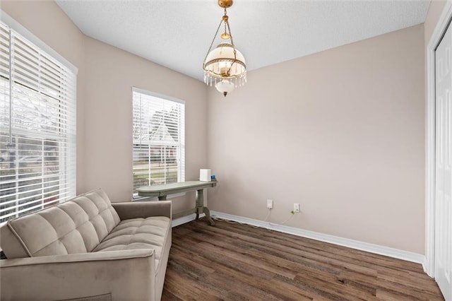 sitting room featuring baseboards, a textured ceiling, a chandelier, and dark wood finished floors