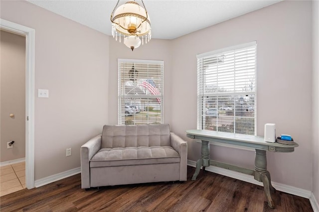 living area with an inviting chandelier, plenty of natural light, and baseboards