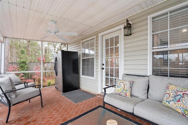 sunroom featuring wood ceiling and a ceiling fan