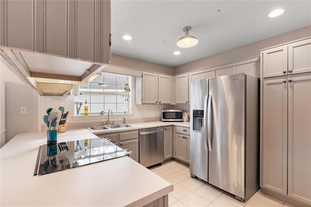 kitchen featuring light countertops, light tile patterned floors, recessed lighting, appliances with stainless steel finishes, and a sink