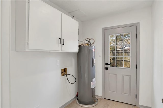 clothes washing area featuring washer hookup, electric water heater, light hardwood / wood-style floors, and cabinets