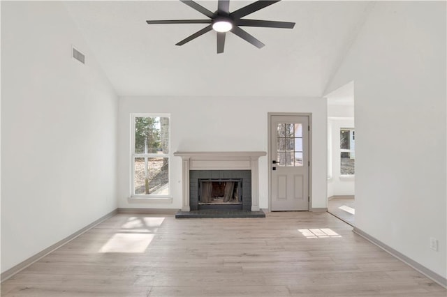 unfurnished living room with ceiling fan, high vaulted ceiling, a fireplace, and light hardwood / wood-style floors