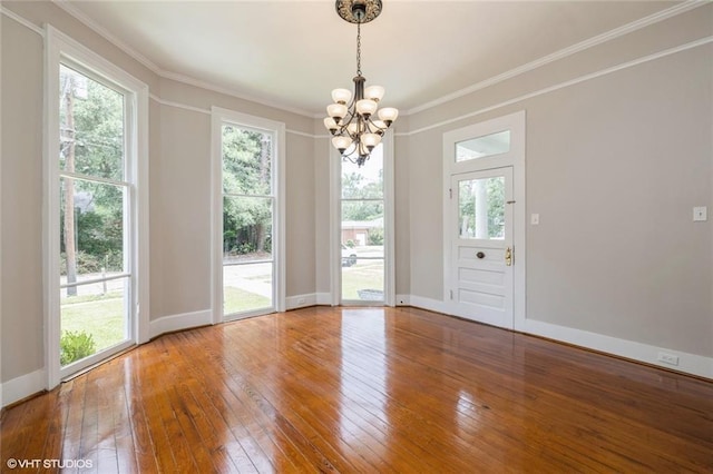 unfurnished dining area with ornamental molding, hardwood / wood-style flooring, and a notable chandelier