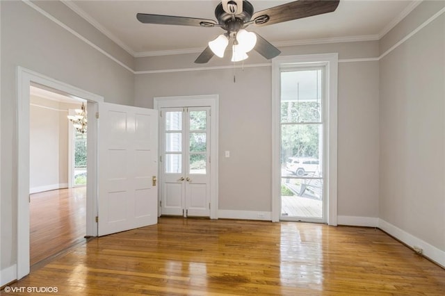 foyer with hardwood / wood-style floors, ceiling fan with notable chandelier, and ornamental molding