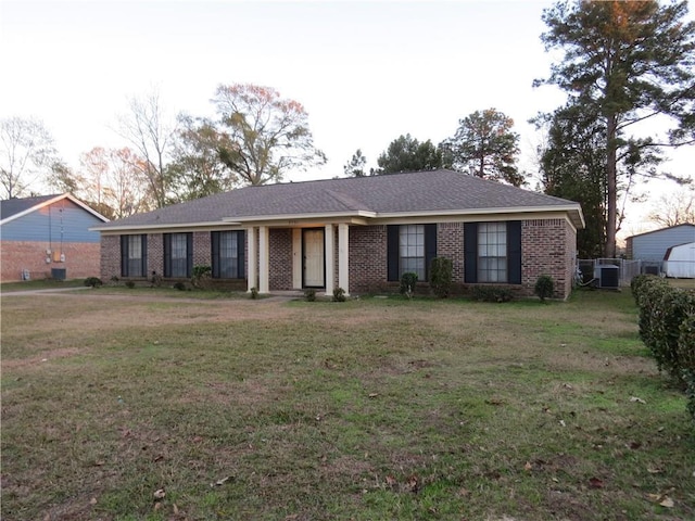 ranch-style house with central AC unit and a front lawn