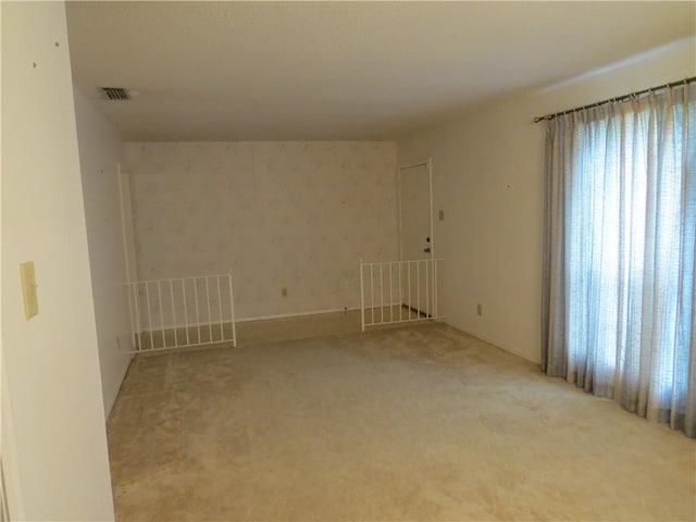 unfurnished room featuring light carpet