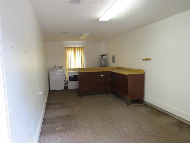 unfurnished office featuring dark carpet, washer / clothes dryer, water heater, and a textured ceiling