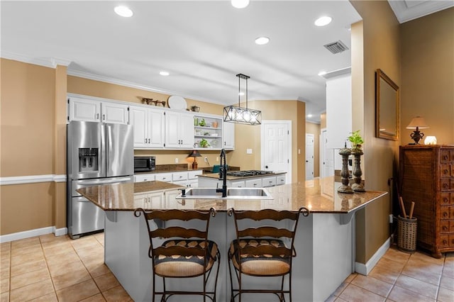 kitchen with appliances with stainless steel finishes, kitchen peninsula, hanging light fixtures, a kitchen breakfast bar, and white cabinets