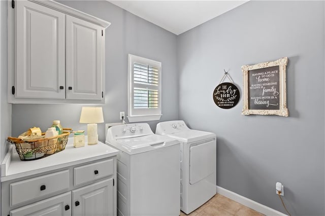 laundry area with washer and clothes dryer, light tile patterned flooring, and cabinets