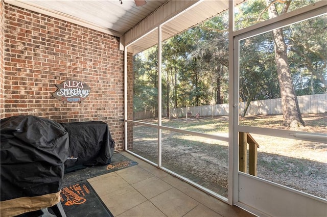 sunroom featuring ceiling fan and wooden ceiling