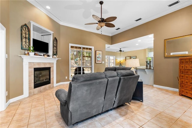 tiled living room featuring ornamental molding, a fireplace, and ceiling fan