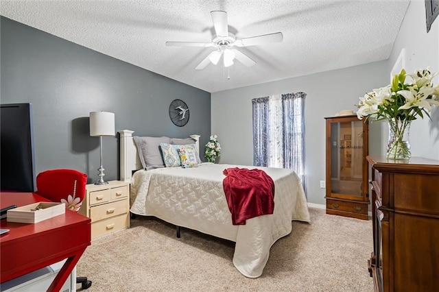 carpeted bedroom with a ceiling fan and a textured ceiling