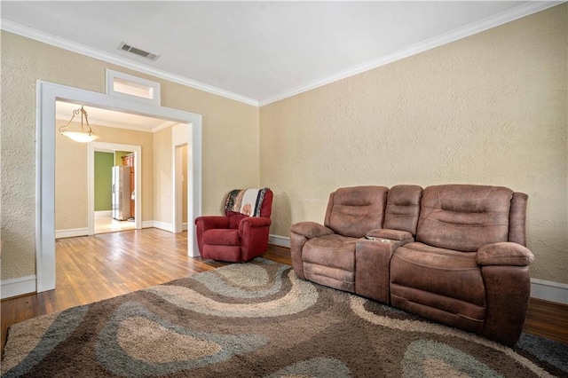 603 Glenwood St, Mobile, AL 36606 - living room featuring wood finished floors, ornamental molding, a textured wall, and baseboards