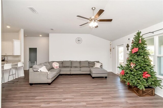 living room with ceiling fan, light hardwood / wood-style floors, and lofted ceiling