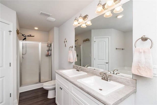 bathroom featuring vanity, wood-type flooring, an enclosed shower, and toilet