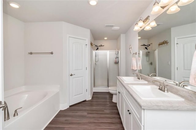 full bathroom with vanity, toilet, plus walk in shower, and hardwood / wood-style flooring