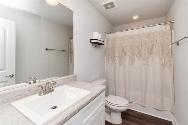 full bathroom featuring hardwood / wood-style floors, vanity, shower / bath combination with curtain, and toilet