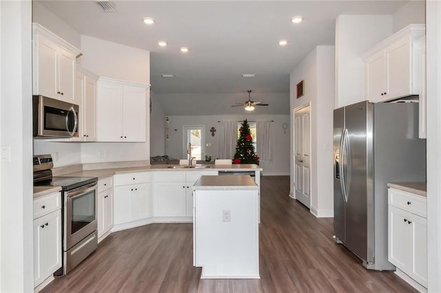 kitchen featuring a center island, ceiling fan, dark hardwood / wood-style flooring, kitchen peninsula, and stainless steel appliances