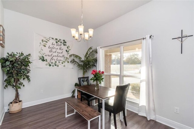 dining space with dark hardwood / wood-style flooring and a chandelier