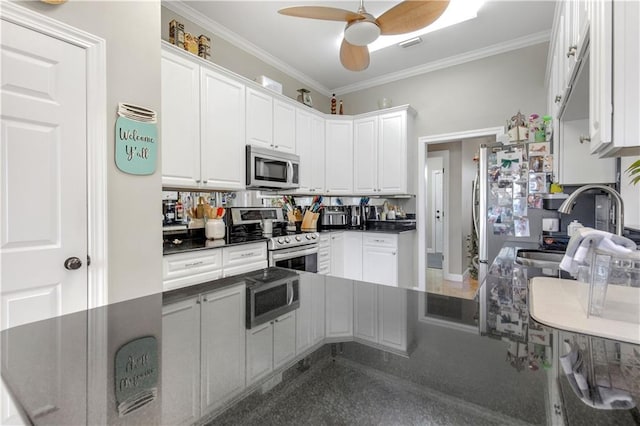 kitchen featuring kitchen peninsula, appliances with stainless steel finishes, white cabinetry, and ornamental molding