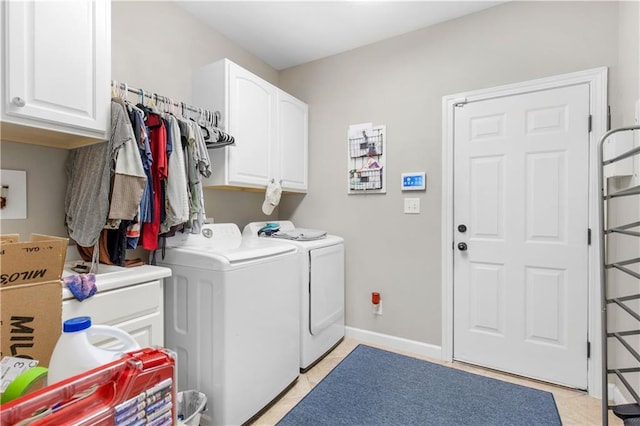 laundry area featuring cabinets, light tile patterned floors, and washing machine and clothes dryer