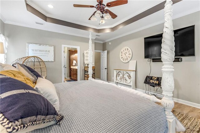 bedroom featuring hardwood / wood-style flooring, ceiling fan, ornamental molding, and connected bathroom