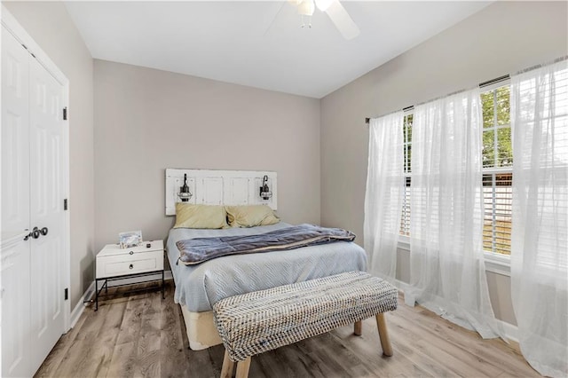 bedroom featuring ceiling fan, light hardwood / wood-style floors, and a closet