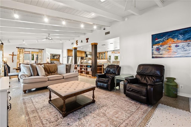 living room with ceiling fan, beamed ceiling, track lighting, and plenty of natural light