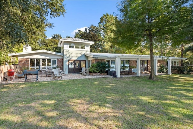 rear view of property featuring a patio and a yard