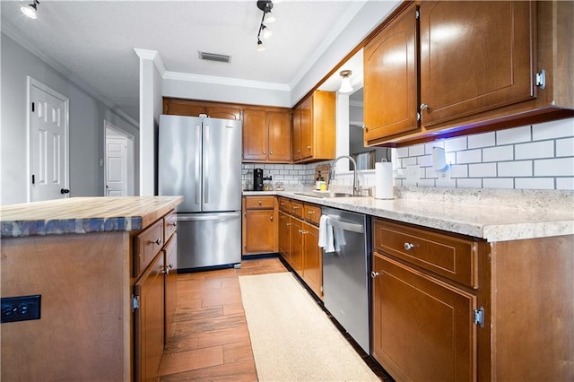 kitchen featuring brown cabinetry, visible vents, stainless steel appliances, and light countertops