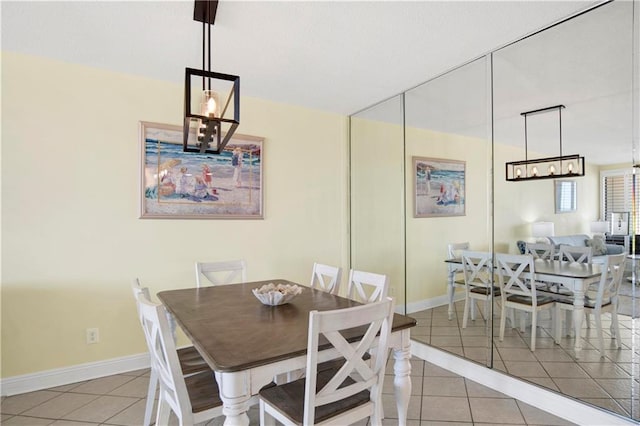 dining room with light tile patterned flooring, a chandelier, and baseboards