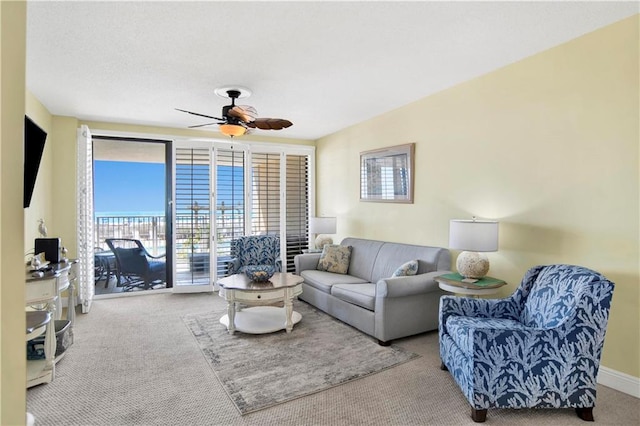 living room featuring a healthy amount of sunlight, a ceiling fan, and carpet