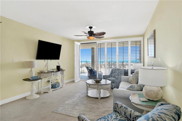 carpeted living room with a wealth of natural light, ceiling fan, and baseboards