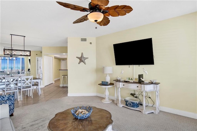 carpeted living room featuring baseboards, visible vents, and ceiling fan