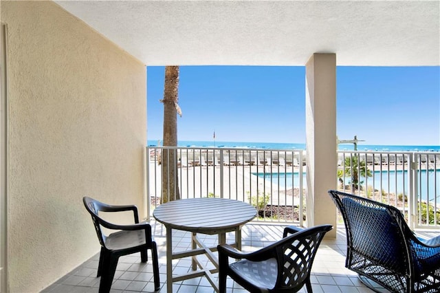 balcony featuring a beach view and a water view