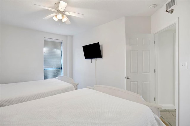 bedroom with ceiling fan, tile patterned floors, and baseboards