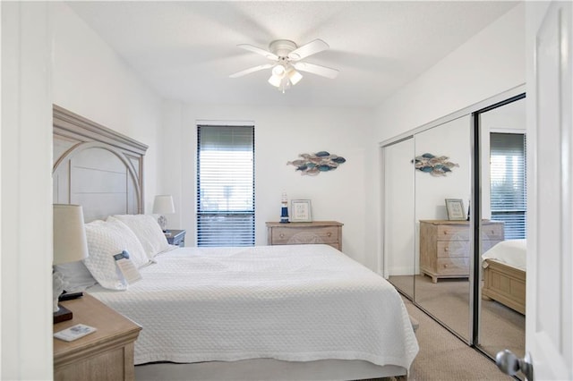 bedroom with ceiling fan, carpet flooring, and a closet