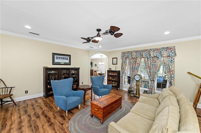 living room with dark hardwood / wood-style flooring, ceiling fan, and crown molding