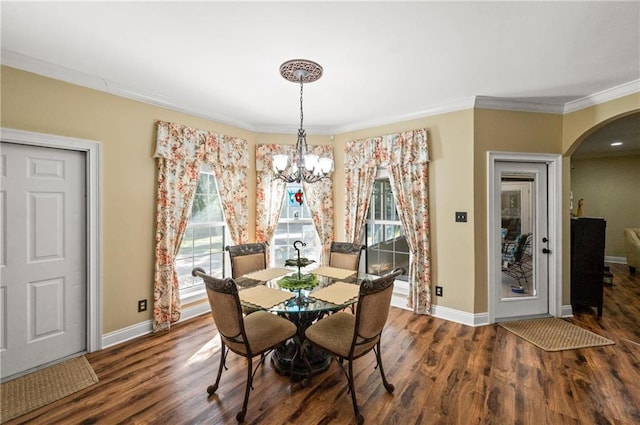 dining room with ornamental molding, dark hardwood / wood-style floors, and a chandelier