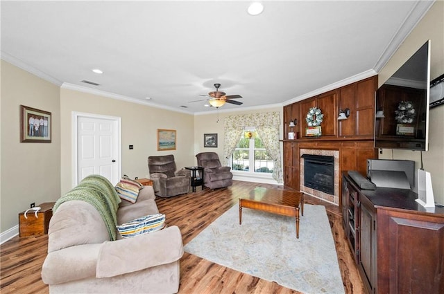 living room with ceiling fan, light hardwood / wood-style flooring, and ornamental molding