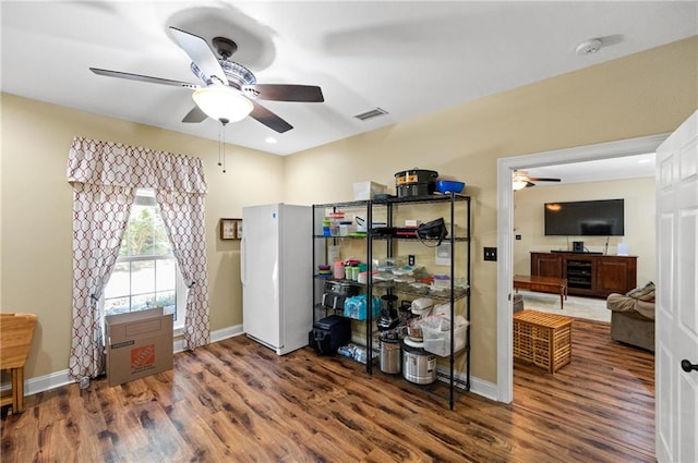 interior space featuring dark hardwood / wood-style flooring, white fridge, and ceiling fan