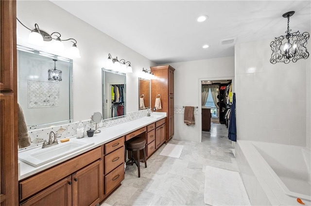 bathroom with a bathtub, vanity, and a chandelier