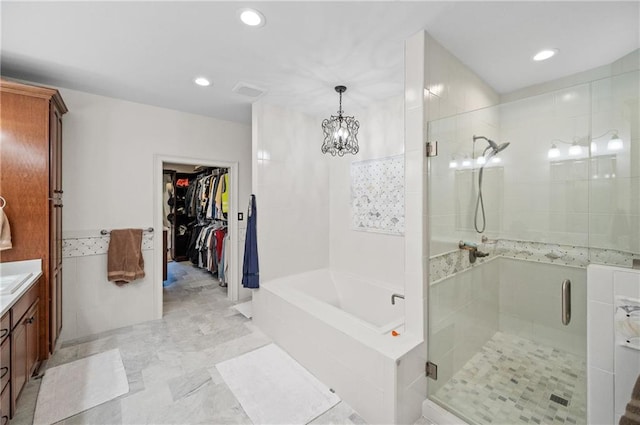 bathroom with a notable chandelier, vanity, and independent shower and bath