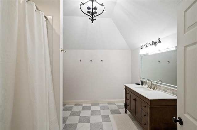 bathroom featuring vanity, decorative backsplash, and vaulted ceiling